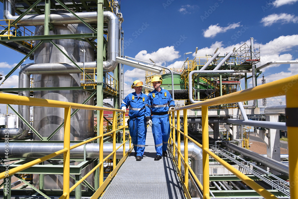 Industrial safety workers inspecting pipelines at a chemical manufacturing plant.