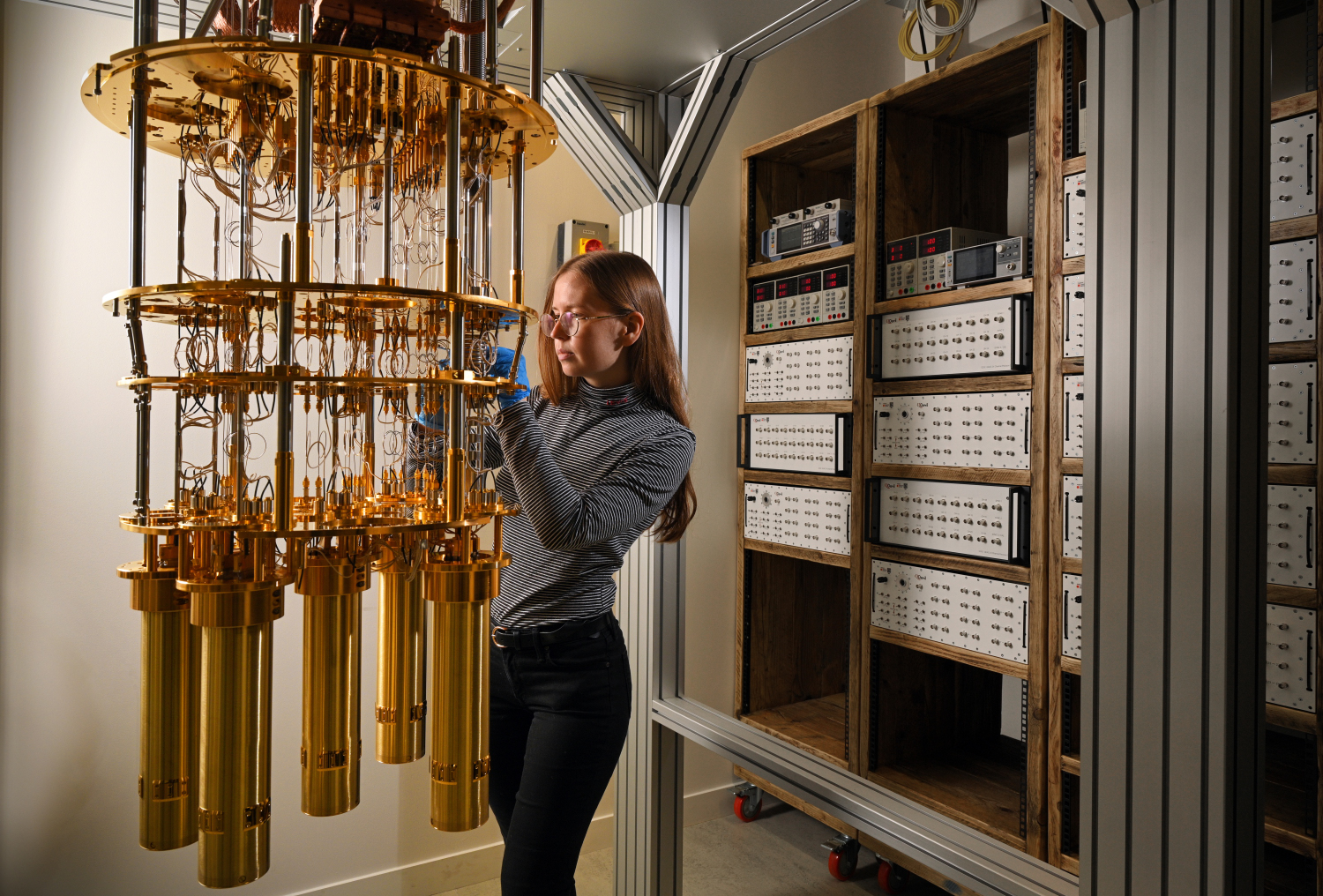 Young female scientist working with quantum device in laboratory.