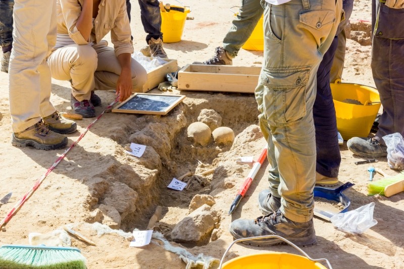 Archaeologists excavating ancient artifacts at a dig site.