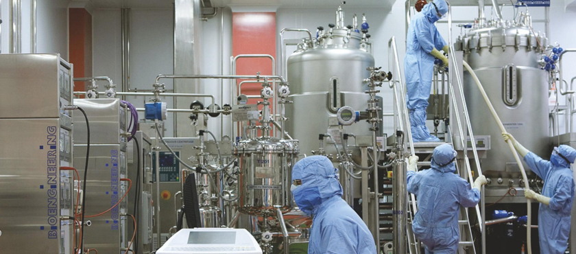 High-tech industrial biotech laboratory with scientists in protective gear operating bioreactors for advanced research.