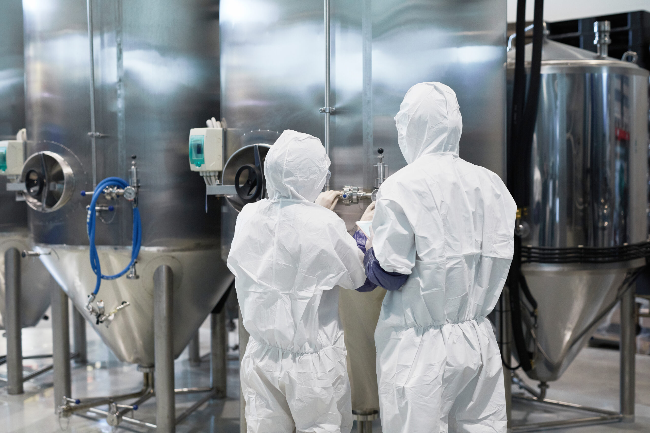 Medical researchers in full protective suits working in a sterile environment.