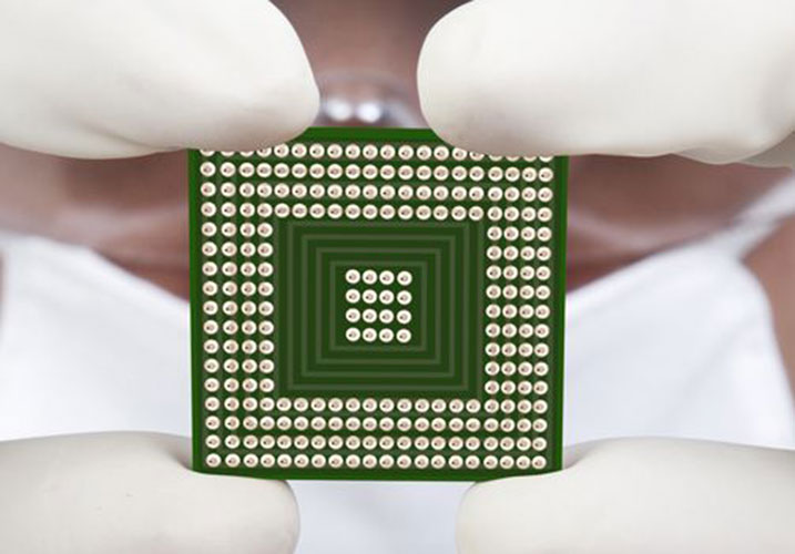 High-resolution microchip held by gloved hands, representing advancements in scientific research and digital technology.