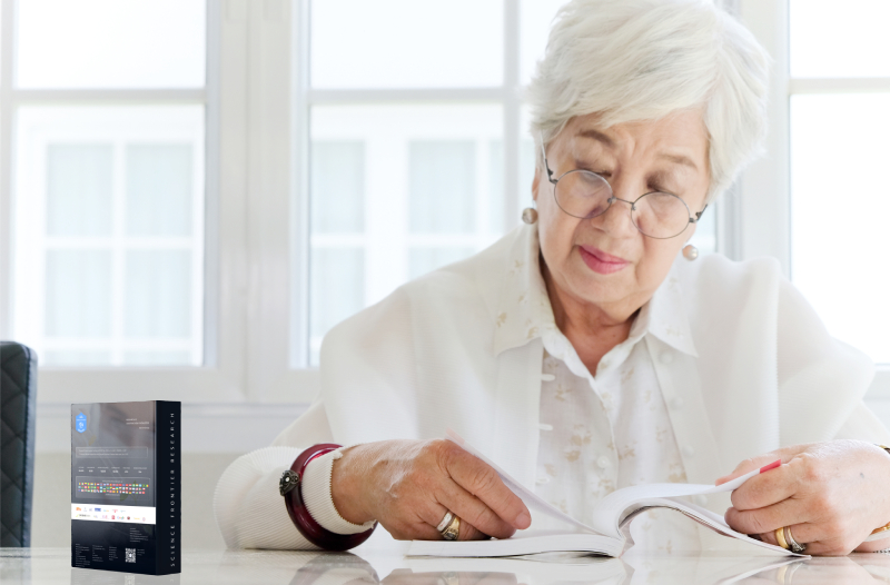 Elderly woman reading research paper in bright office setting.
