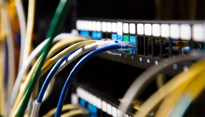 Close-up of a networking switch with colorful Ethernet cables connected, illustrating data communication and connectivity.