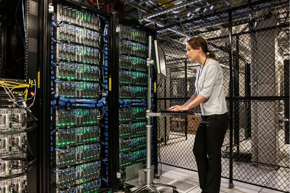 ADA technician analyzing data in server room at data center.