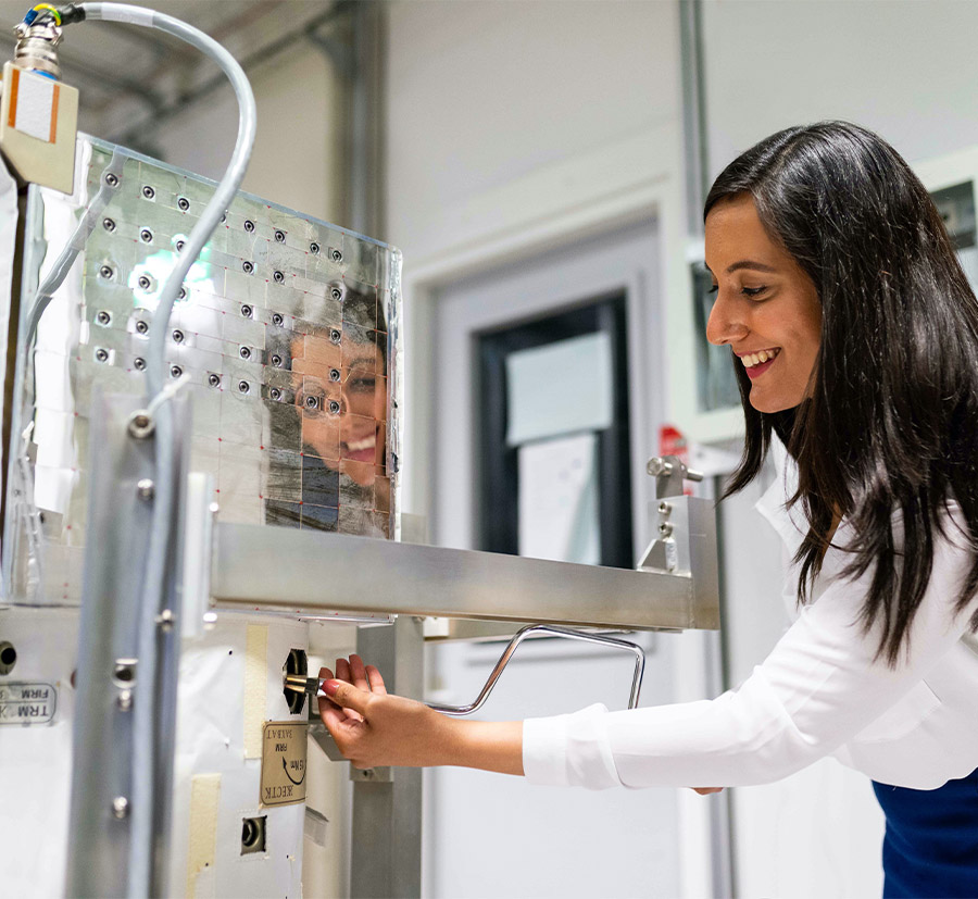 A female researcher adjusts equipment in a laboratory setting, emphasizing innovation in scientific research and technological advancements.