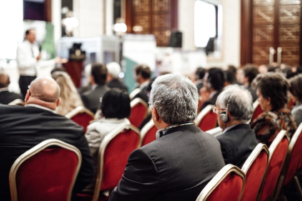 Attendees listening at an academic research conference on "What We Stand For".