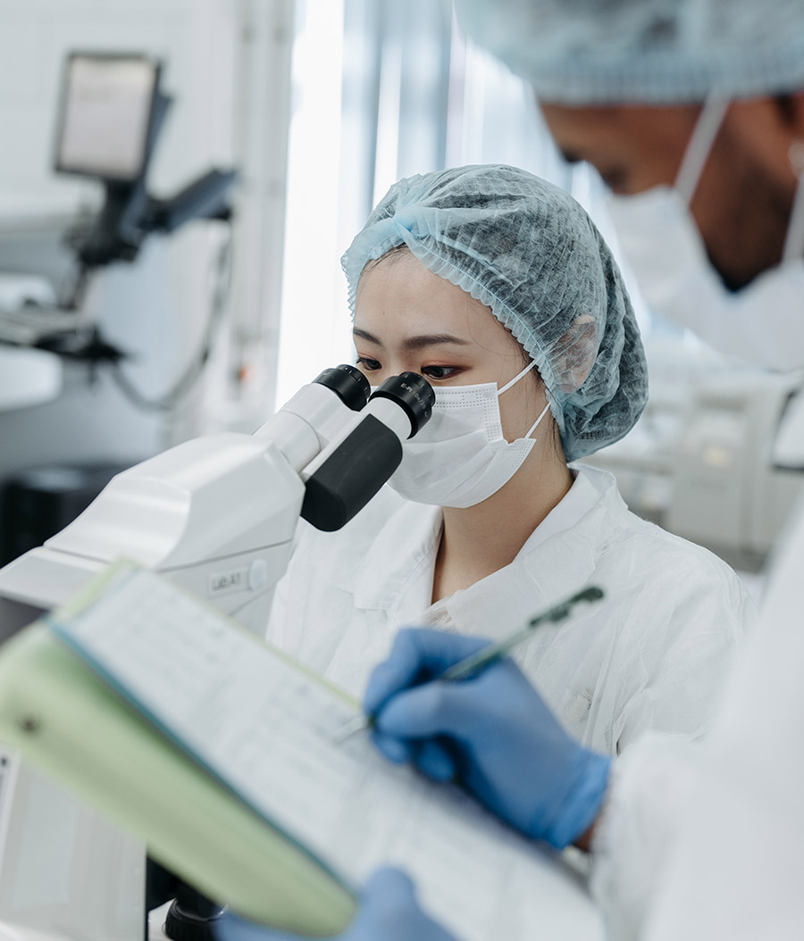 High-resolution medical researcher using microscope in laboratory.