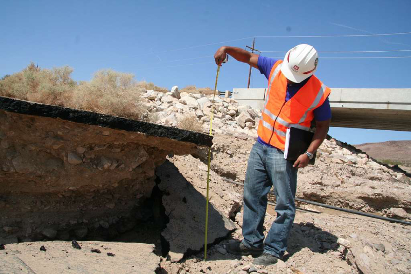 Surveyor measuring ground level at construction site.