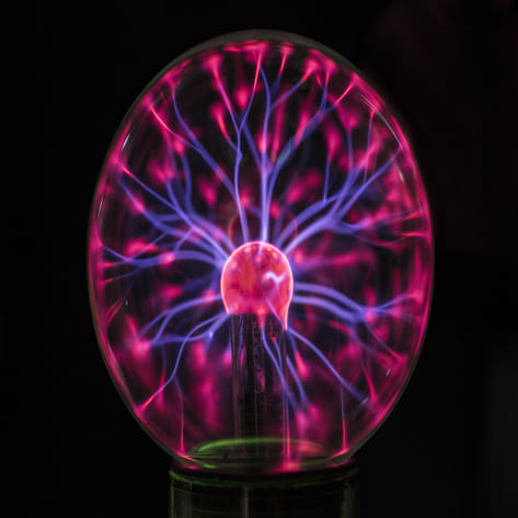 A glowing plasma globe with vibrant pink and blue lightning patterns.