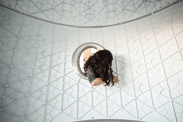 High-resolution photo of a medical research facility showing an MRI scan room with a woman looking into the scanner.