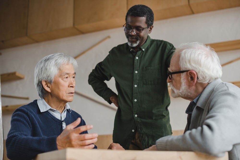 Three men engaged in academic discussion, emphasizing research and collaboration in a professional setting.