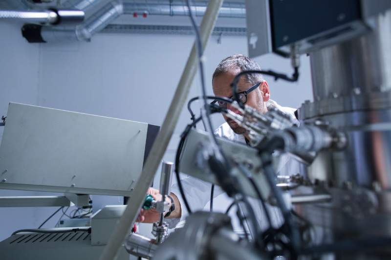 High-tech laboratory environment with scientist manipulating complex scientific instruments.