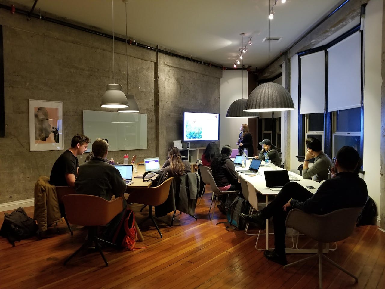 Alt text: Group of diverse professionals attending a research presentation in a modern conference room.