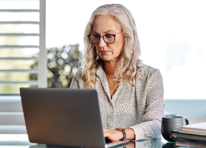 Focused woman working on a laptop for academic research journals.