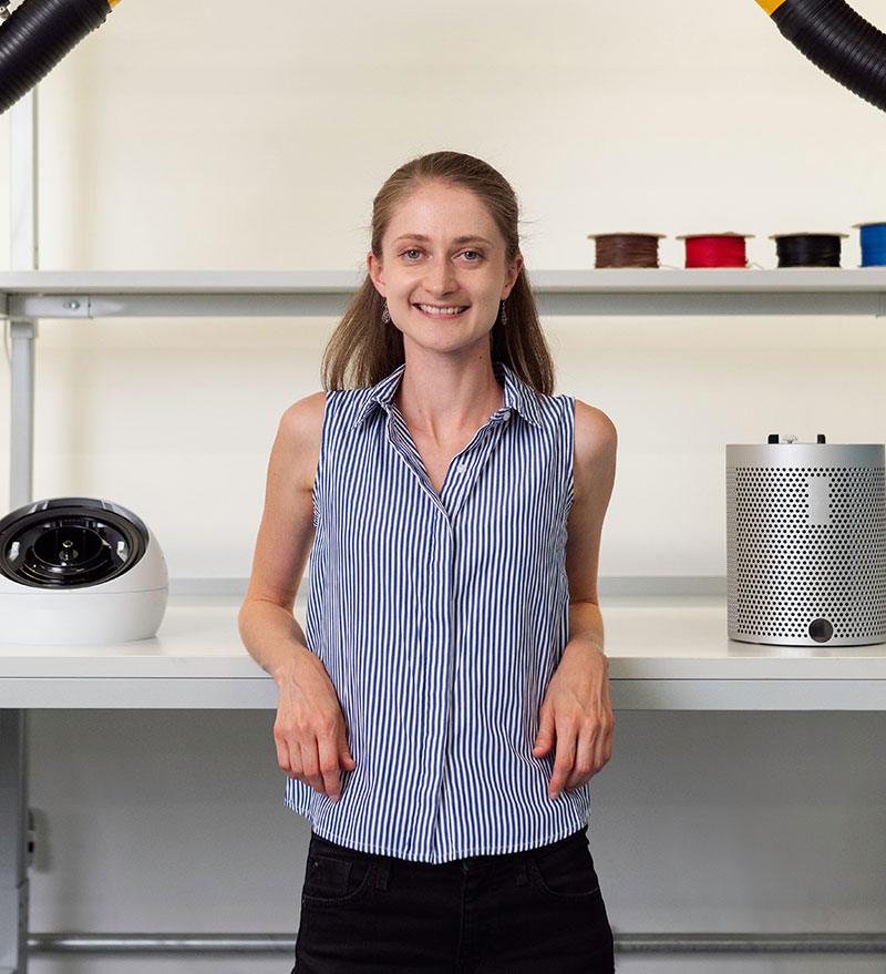 Smiling woman in laboratory with scientific equipment for research and innovation.