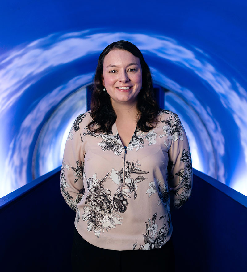 Woman standing in innovative science research tunnel.