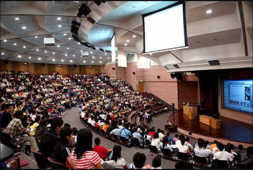 Lecture hall with students attending an academic conference or seminar.