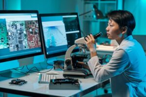 Research scientist examining samples with a microscope in a lab setting.